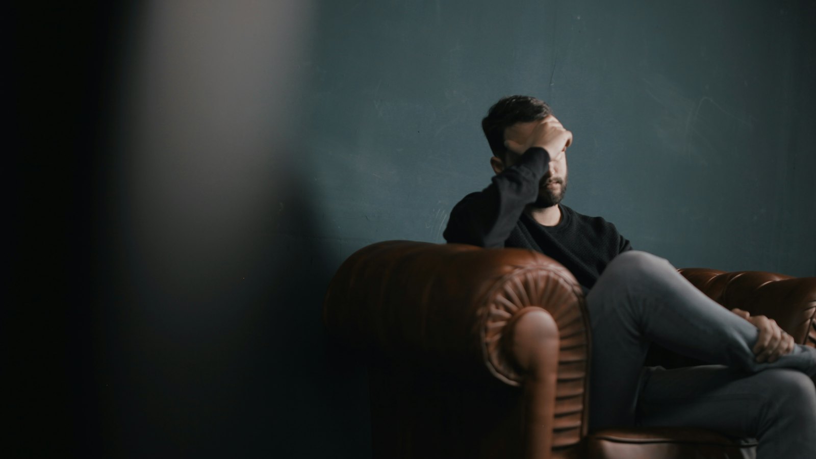 A man on a sofa looking worried