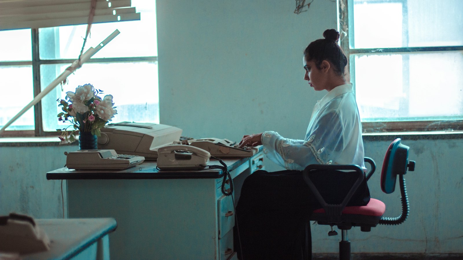 A woman typing at a desk in a bright office
