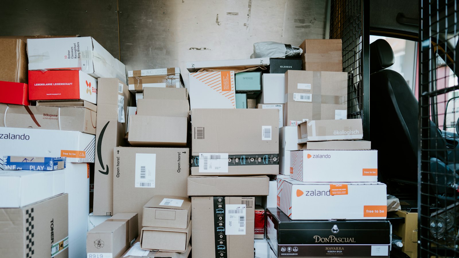 Cardboard shipping boxes stacked in the back of a delivery van