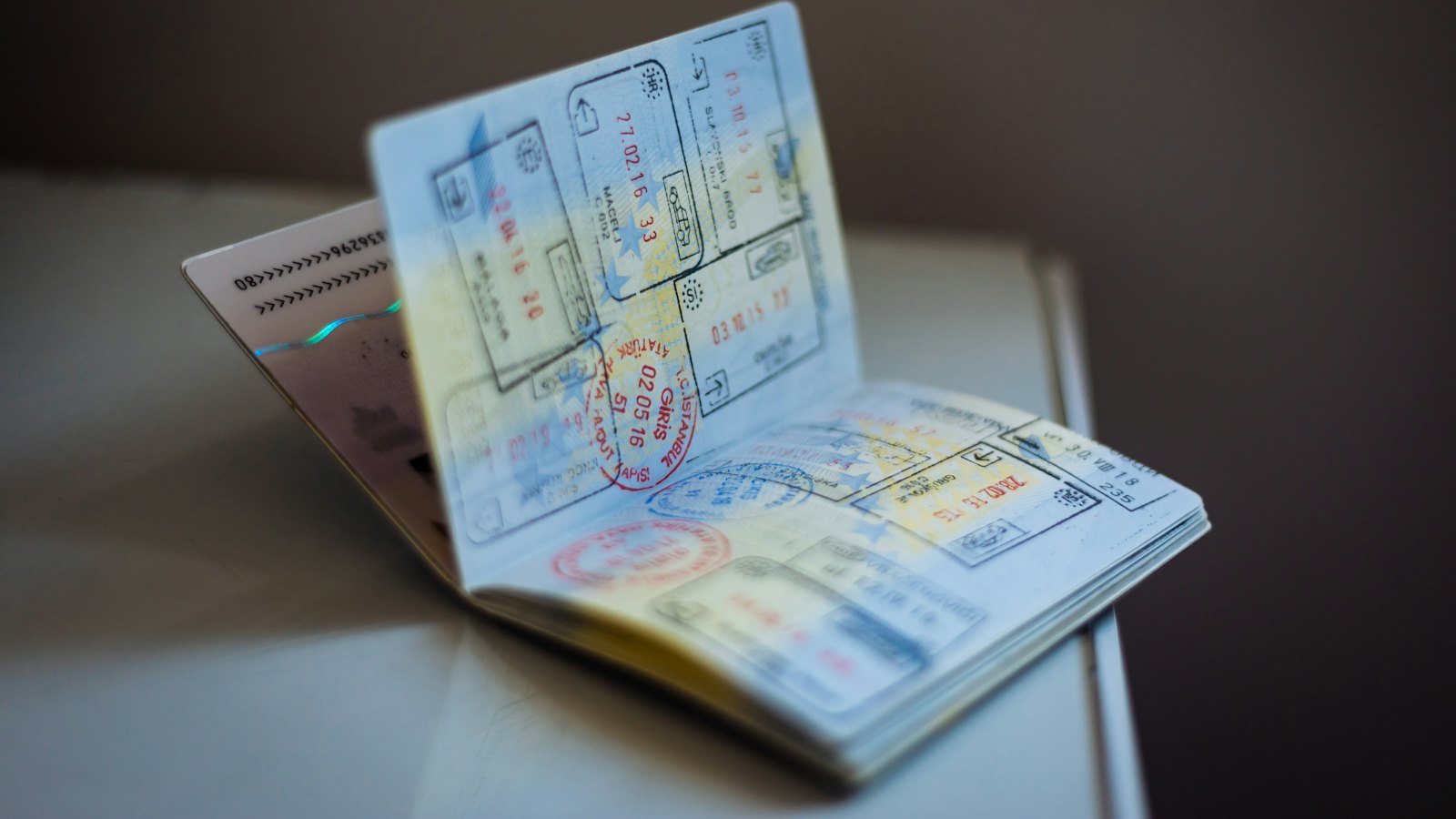 An open passport with visa stamps on a table