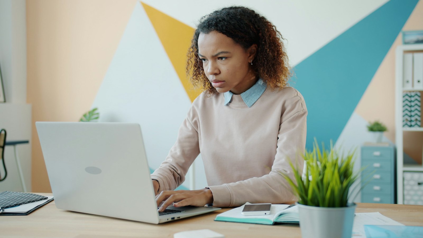 A woman concentrating while working on a laptop