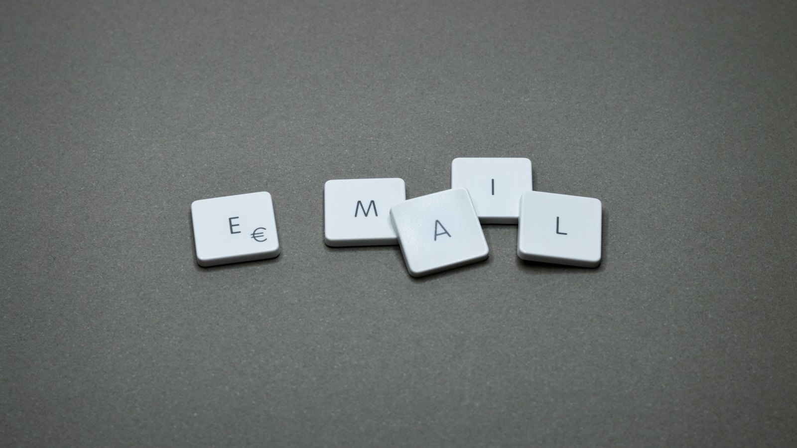 Letter tiles spelling the word email on a grey surface