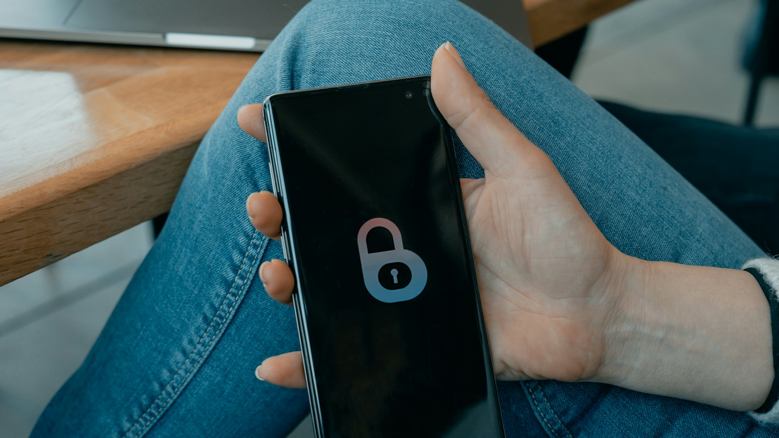 A hand holding a phone showing a padlock icon on the screen