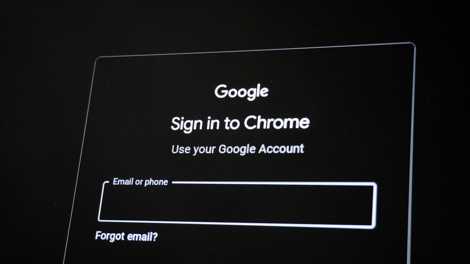 A dark screen showing a Google sign-in page with an email field