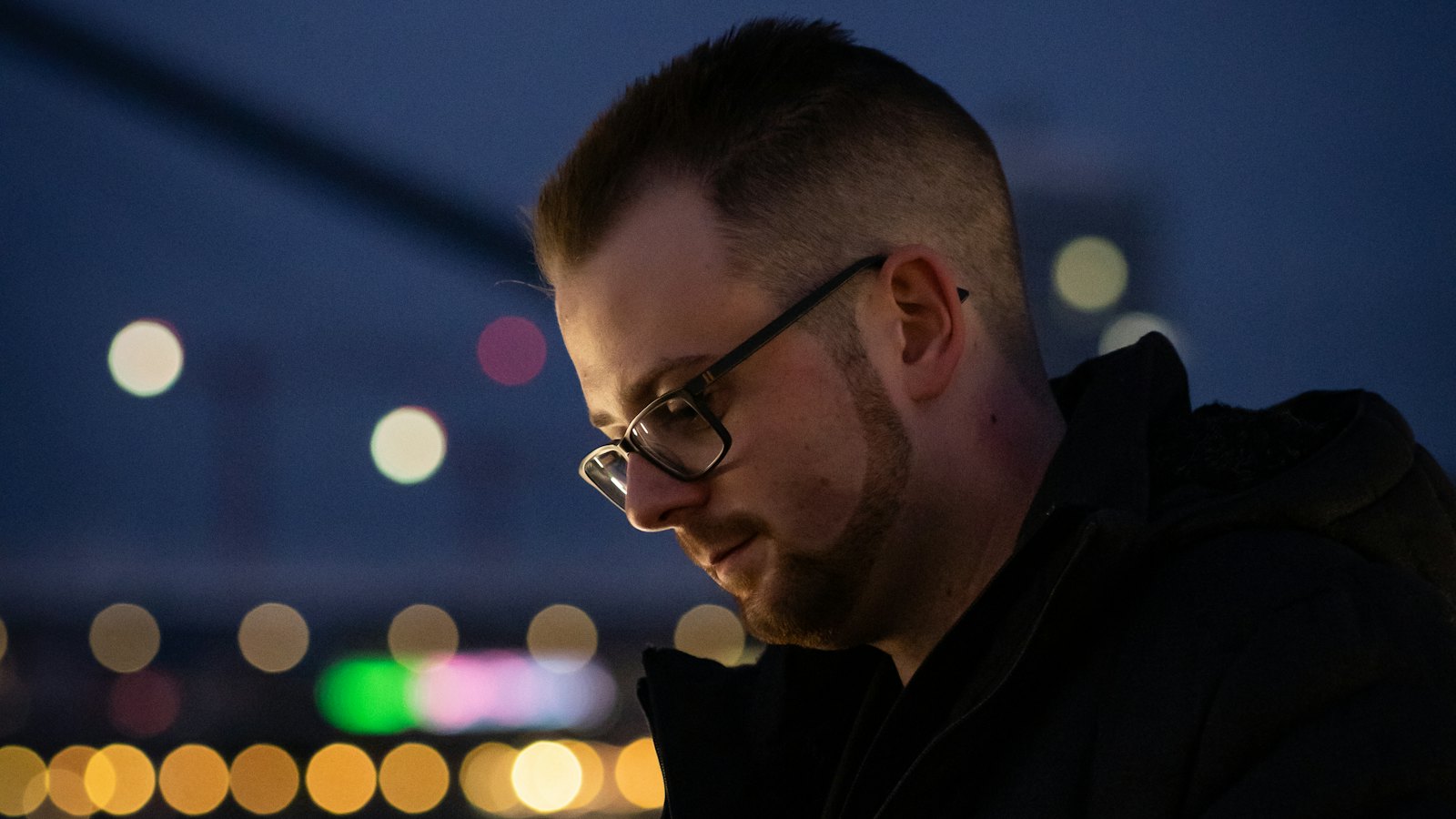 A man looking at his phone at night