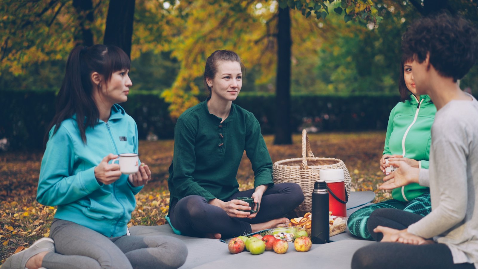 Friends chatting at a picnic in a park