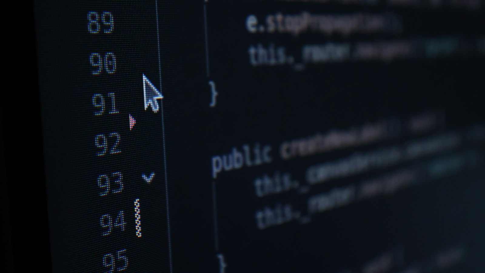 A mouse cursor hovering over lines of code on a dark screen