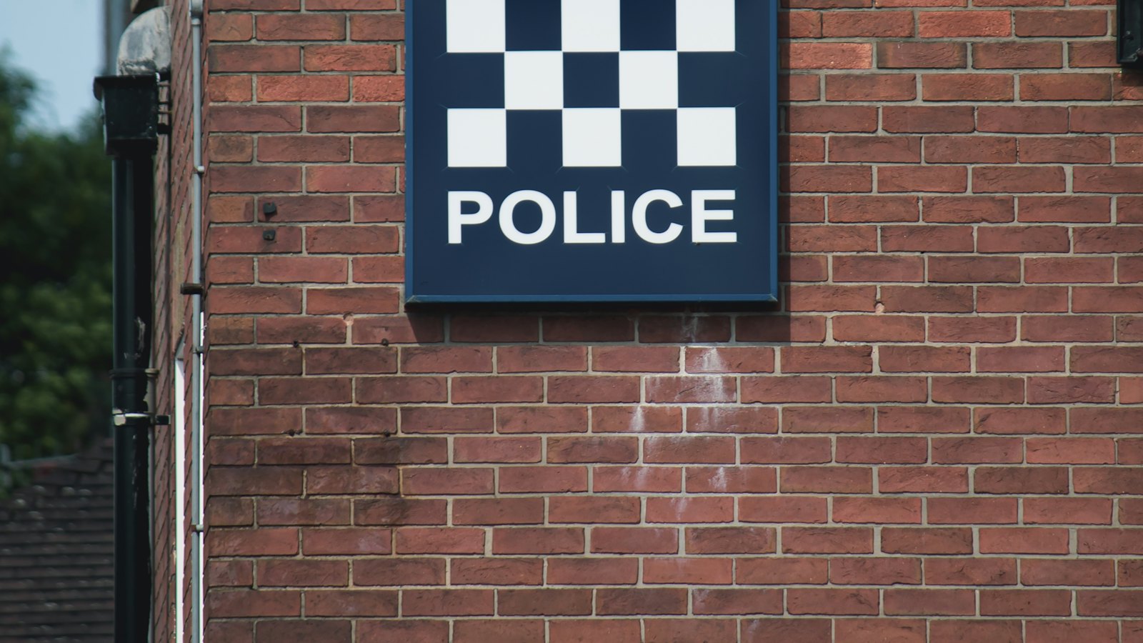 A police sign on a brick wall