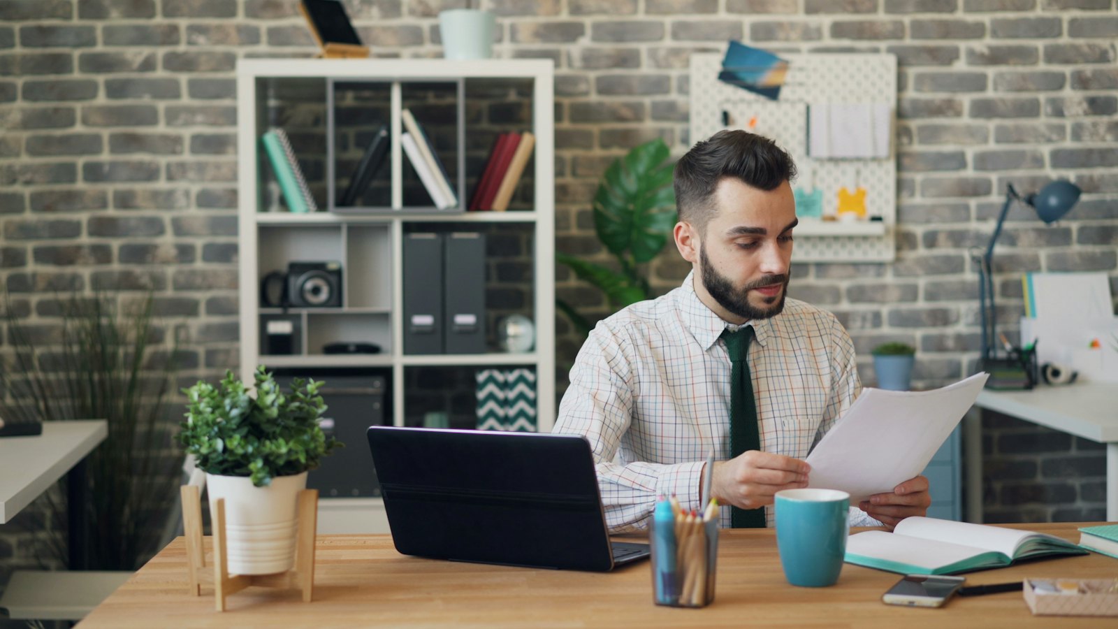 An office worker reading a document at his desk