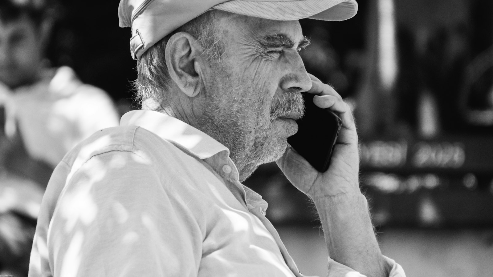 A man in a cap listening on a phone call