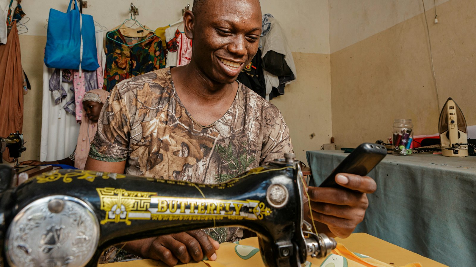 A tailor smiling at his sewing machine