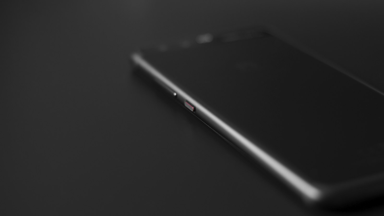 A smartphone with its screen switched off on a dark surface
