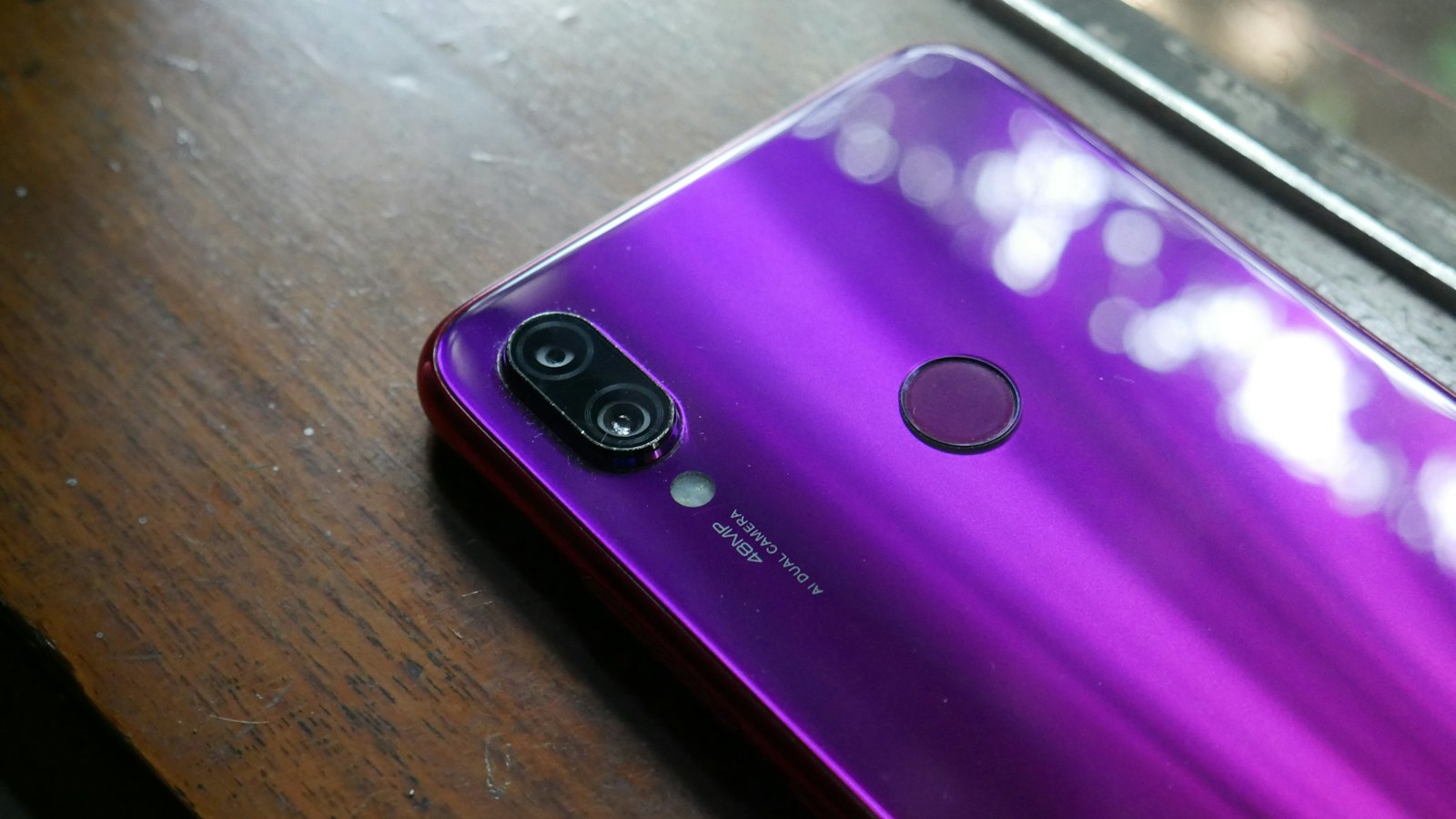 The back of a purple phone with a fingerprint sensor