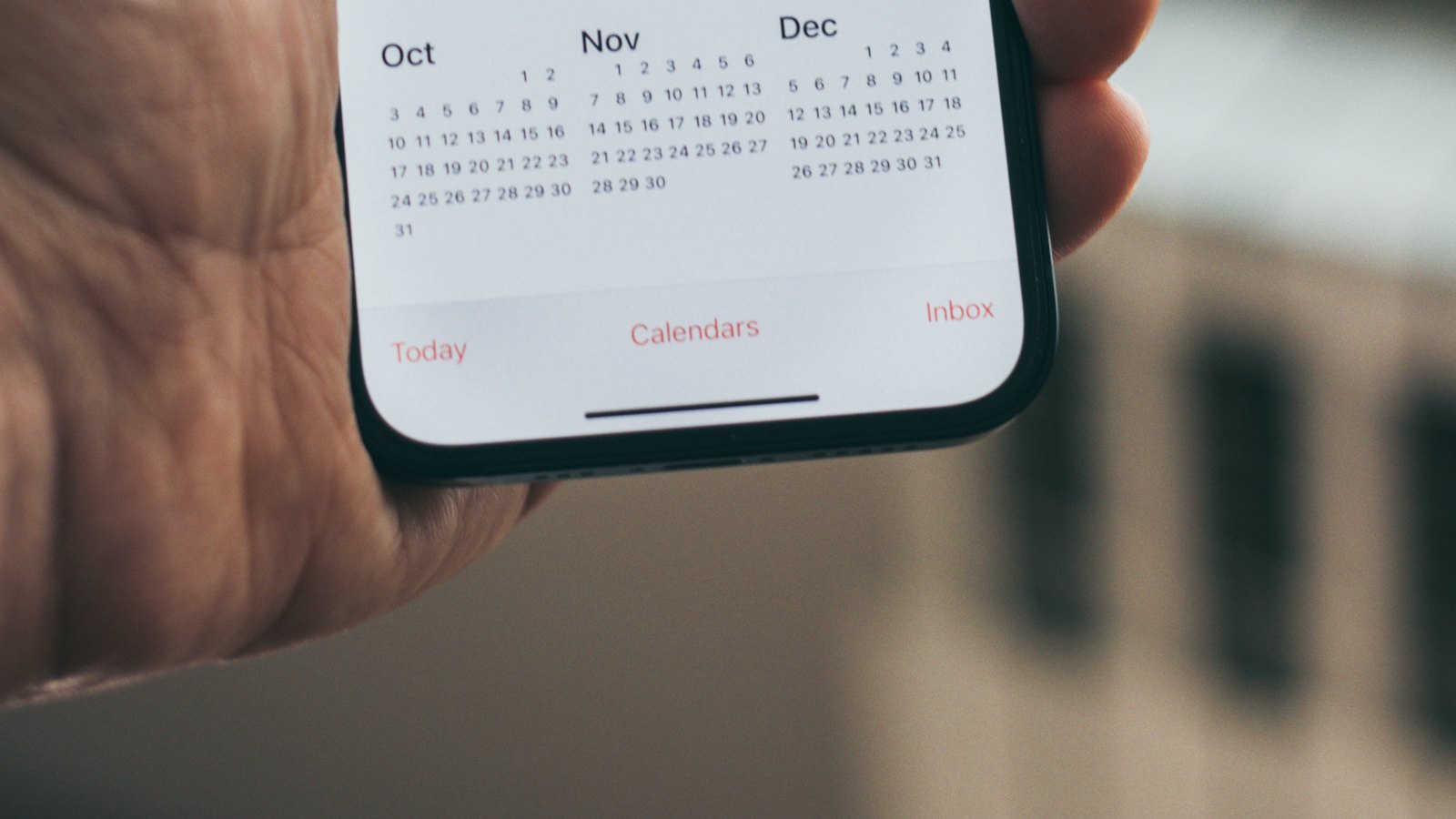 A hand holding a phone showing an app screen