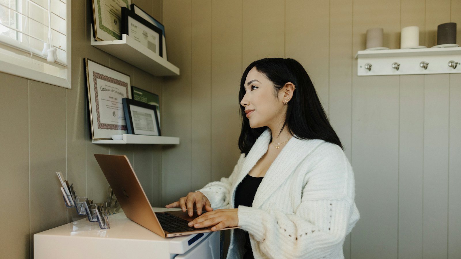 A business owner working on a laptop at a standing desk