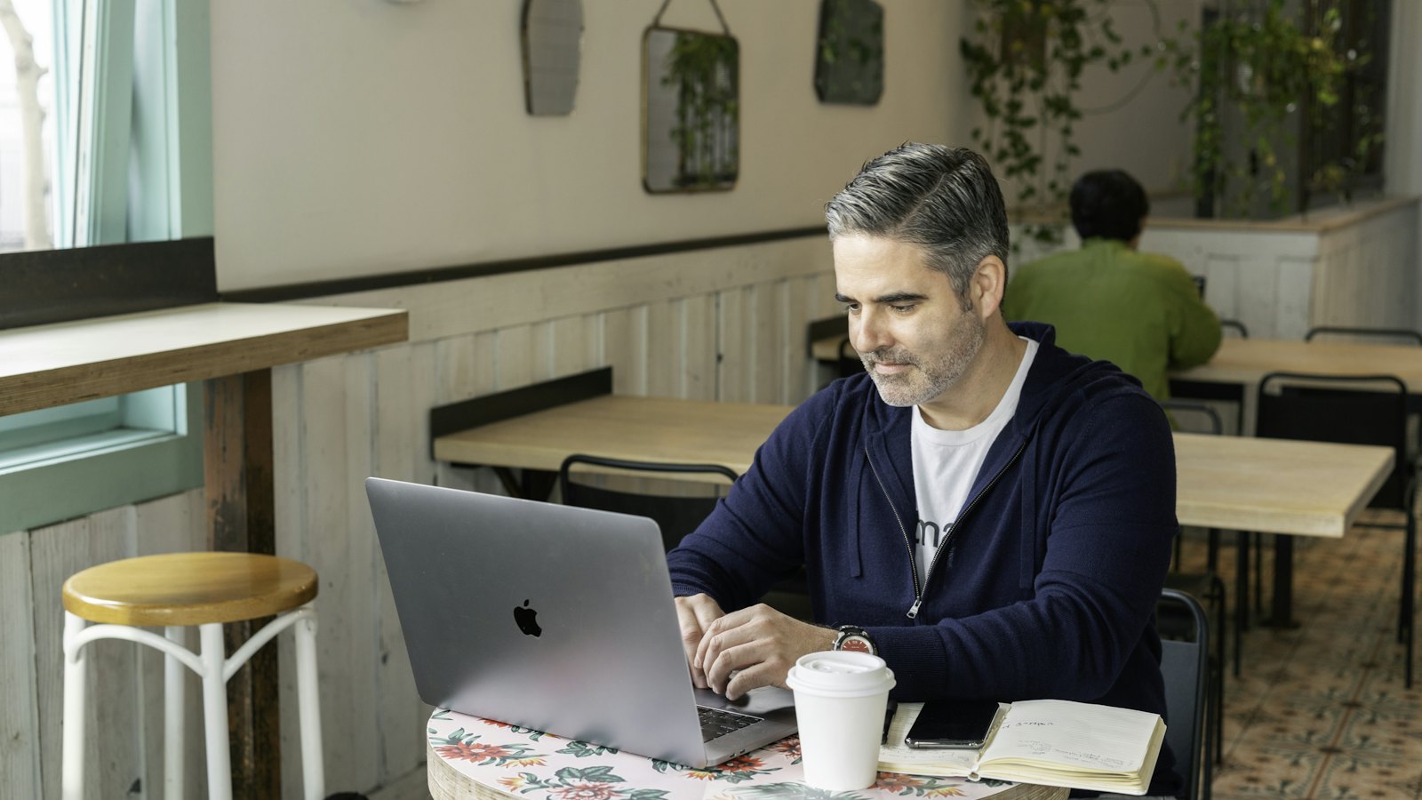 A business owner working on a laptop at a café table