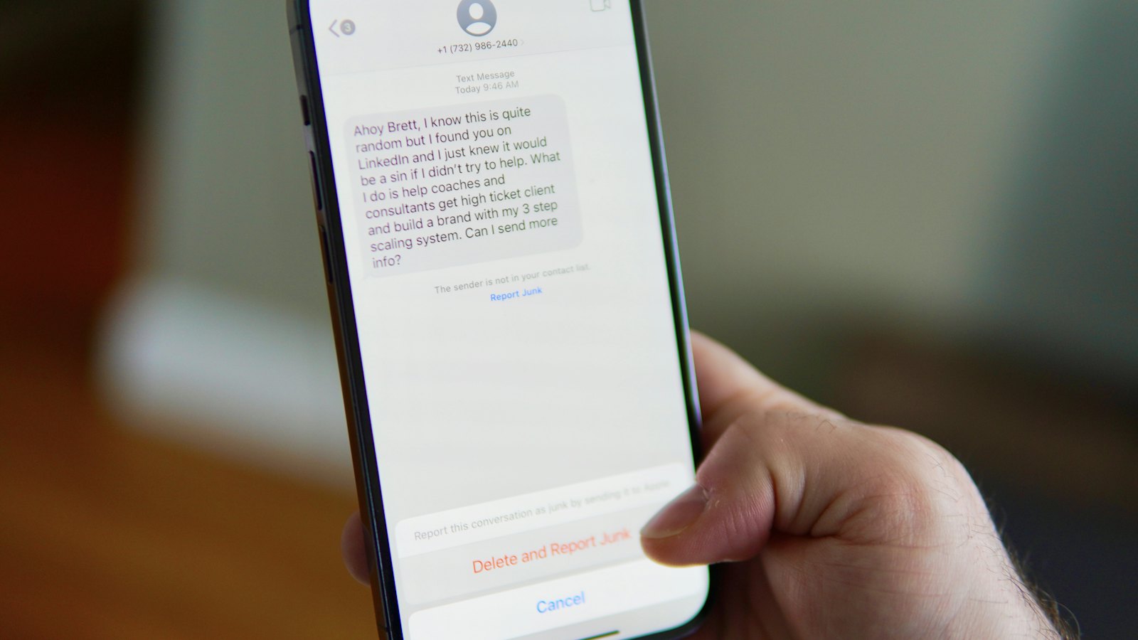 A hand holding a phone with a text message conversation open