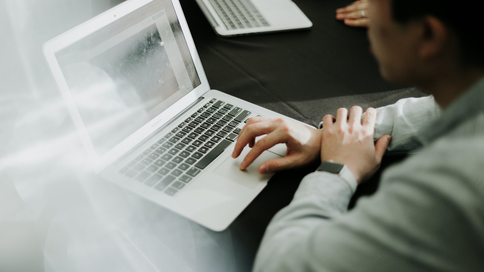 A person typing on a laptop at a desk
