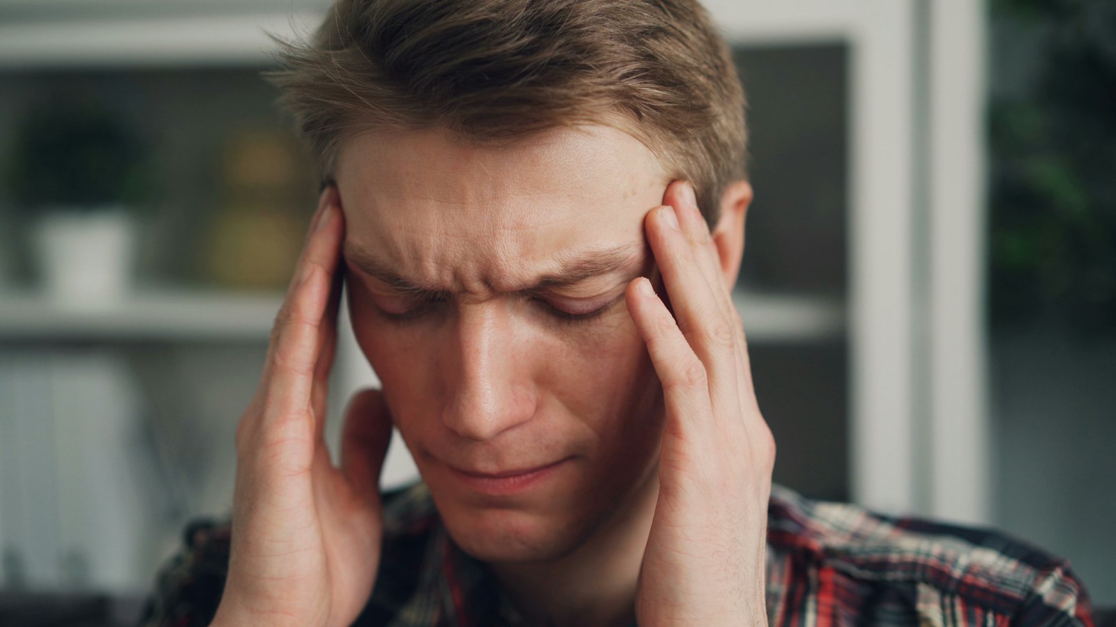 A worried man holding his head