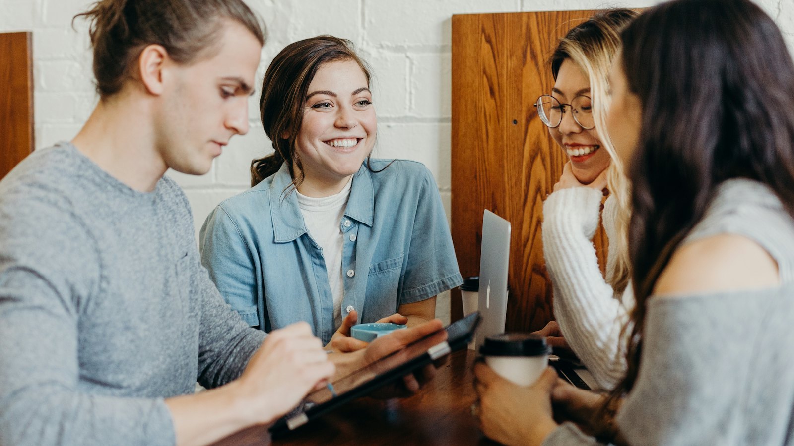 Four young friends chatting around a cafe table