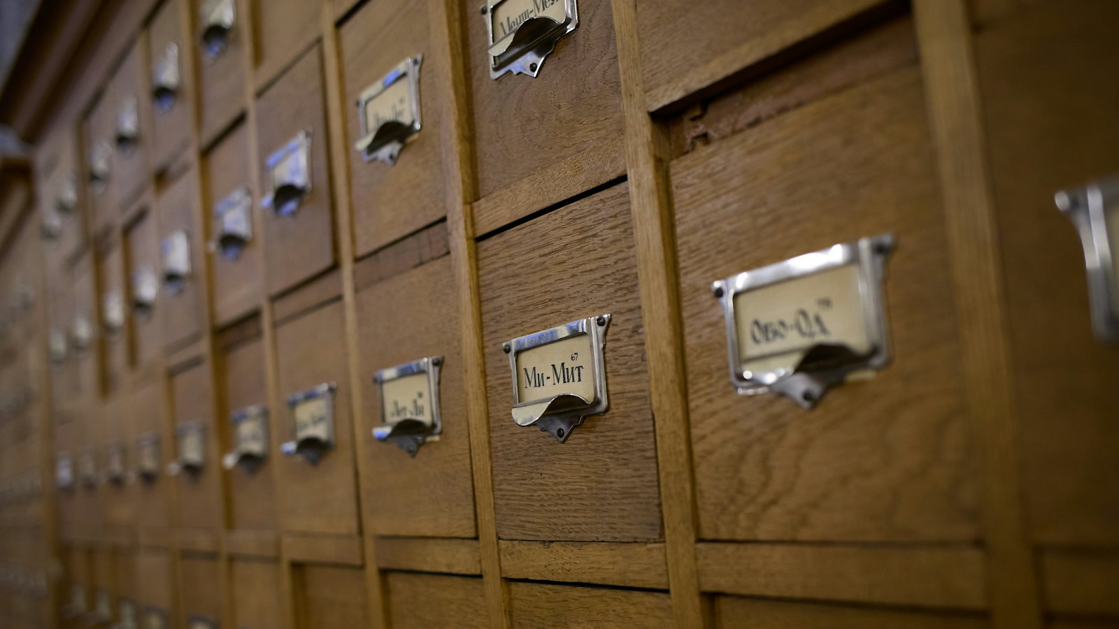 Rows of wooden index card drawers with metal labels