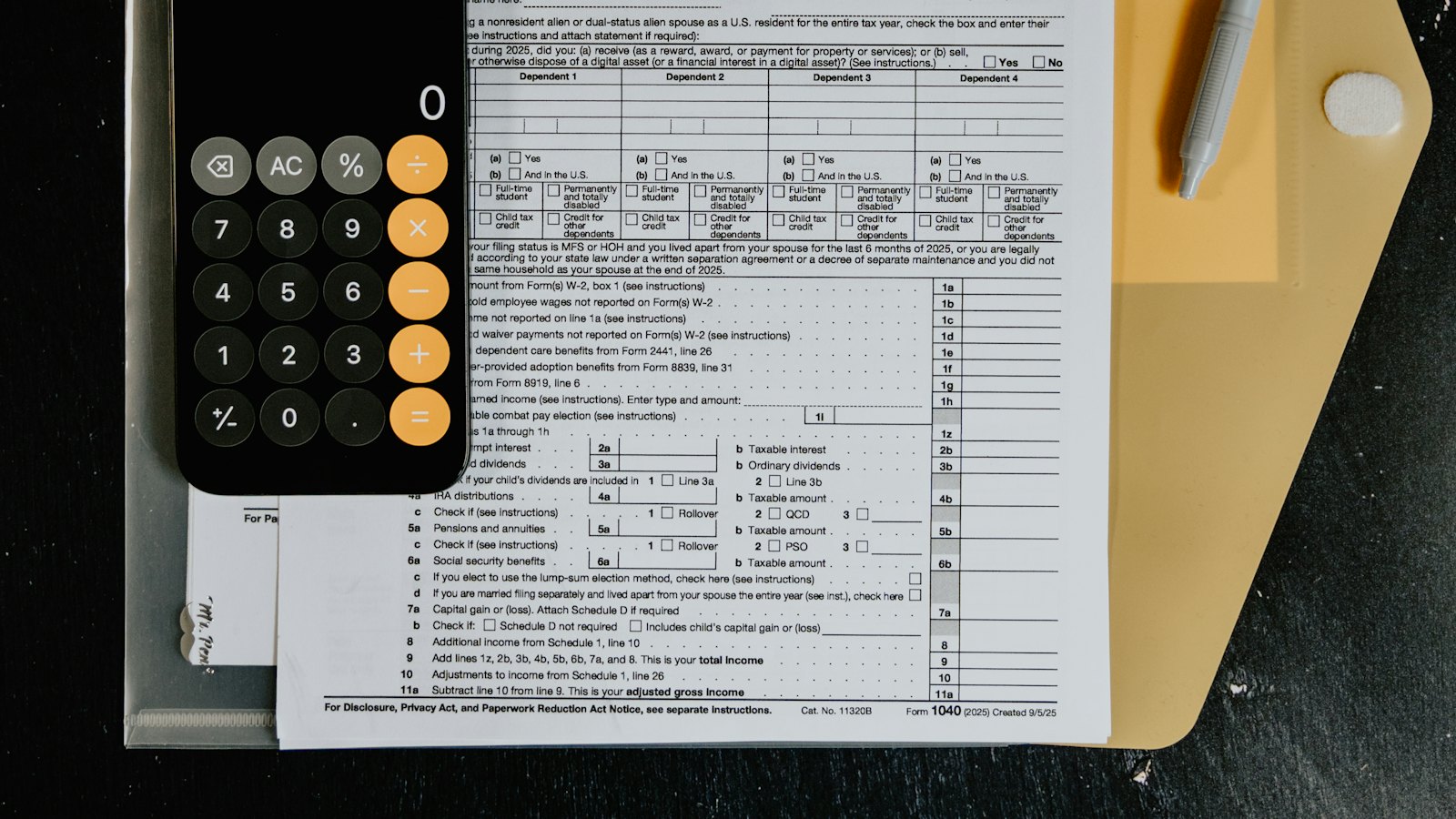 Tax forms with a calculator and a pen on a desk