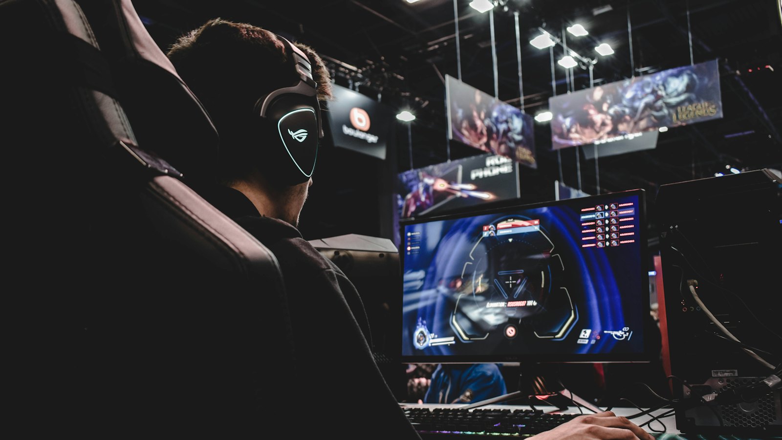 A young person in headphones playing a video game at a computer