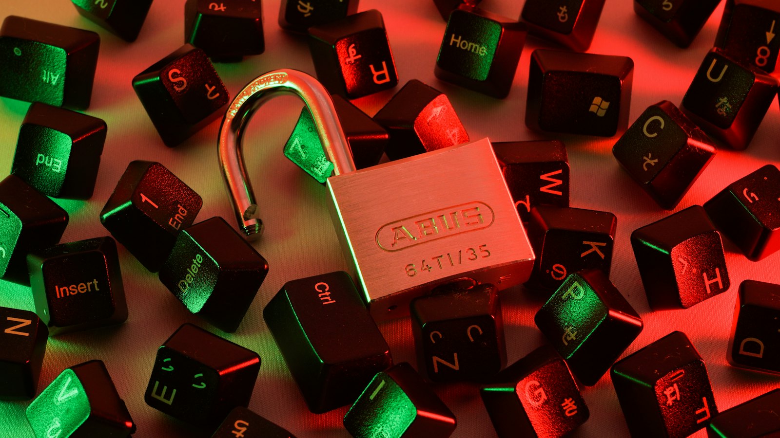 An open padlock among scattered keyboard keys lit in red and green