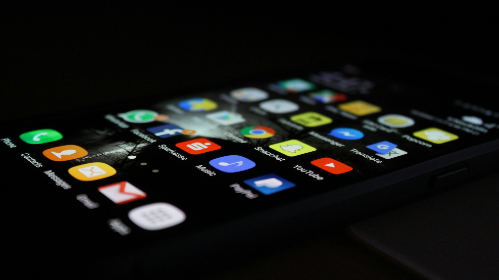 A smartphone home screen full of apps in the dark