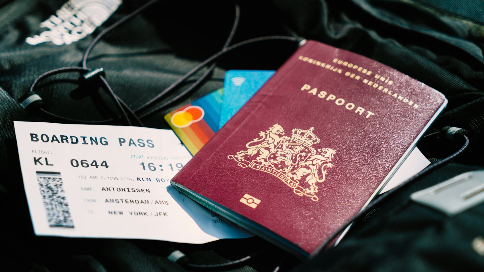 A passport and a boarding pass lying on a black bag