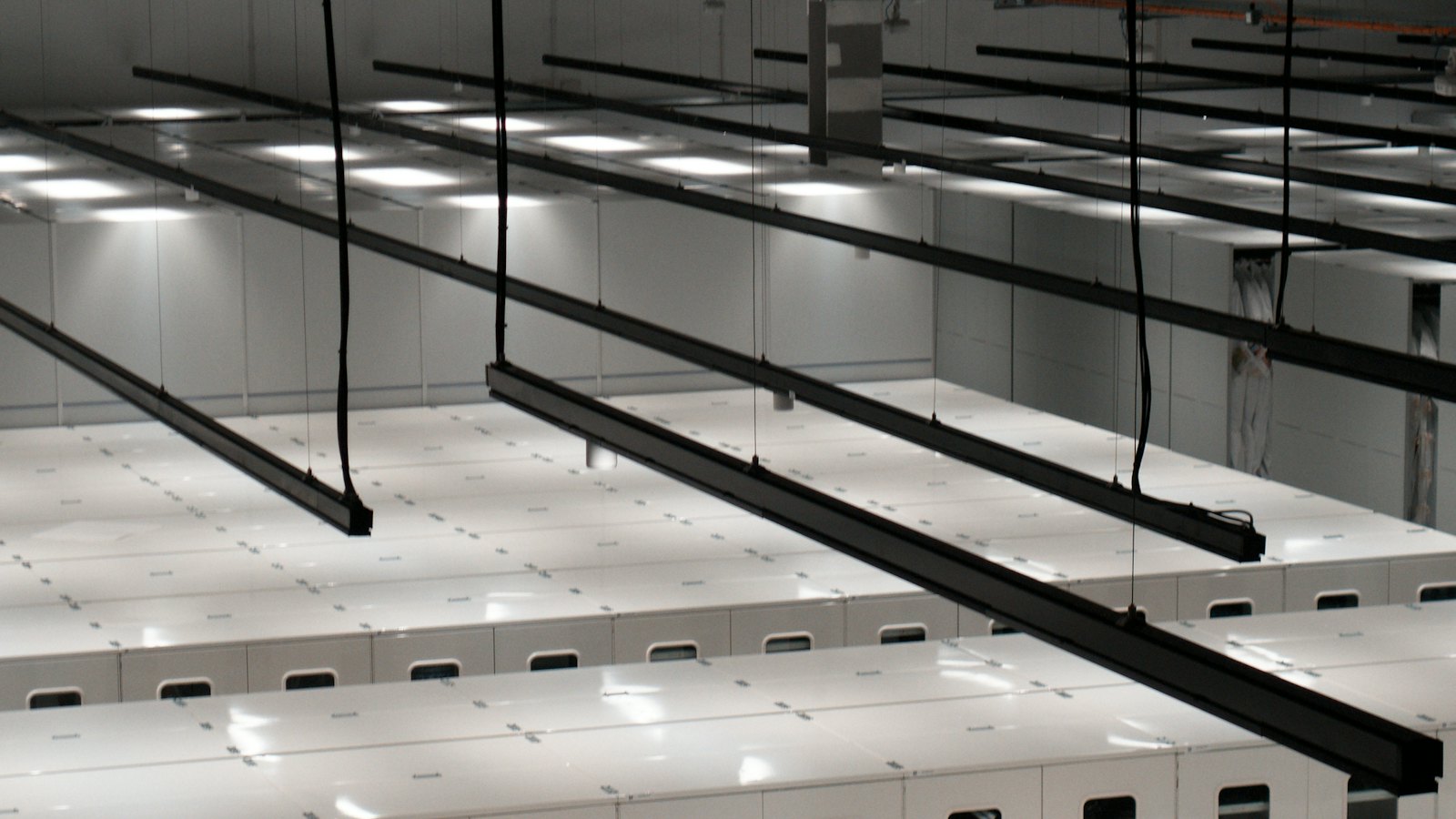 Rows of white server cabinets in a bright data centre