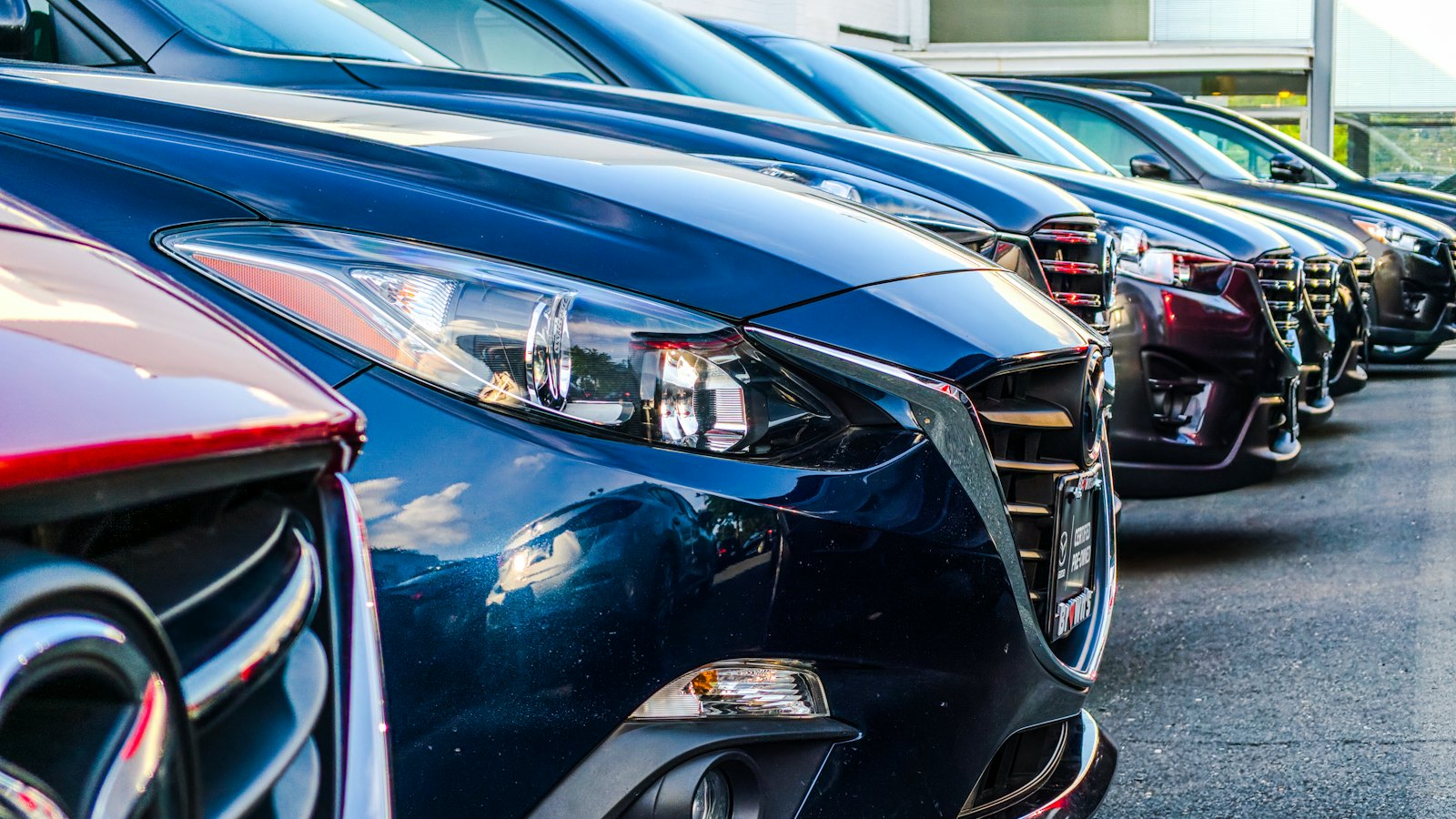 A row of cars parked at a dealership
