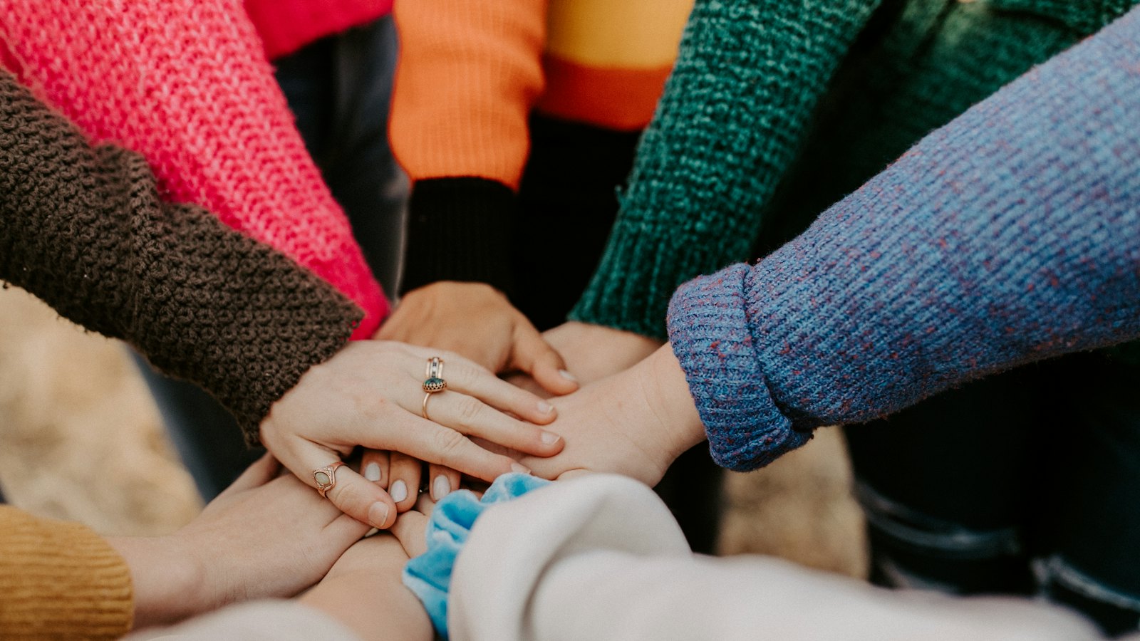 A group of people stacking their hands together