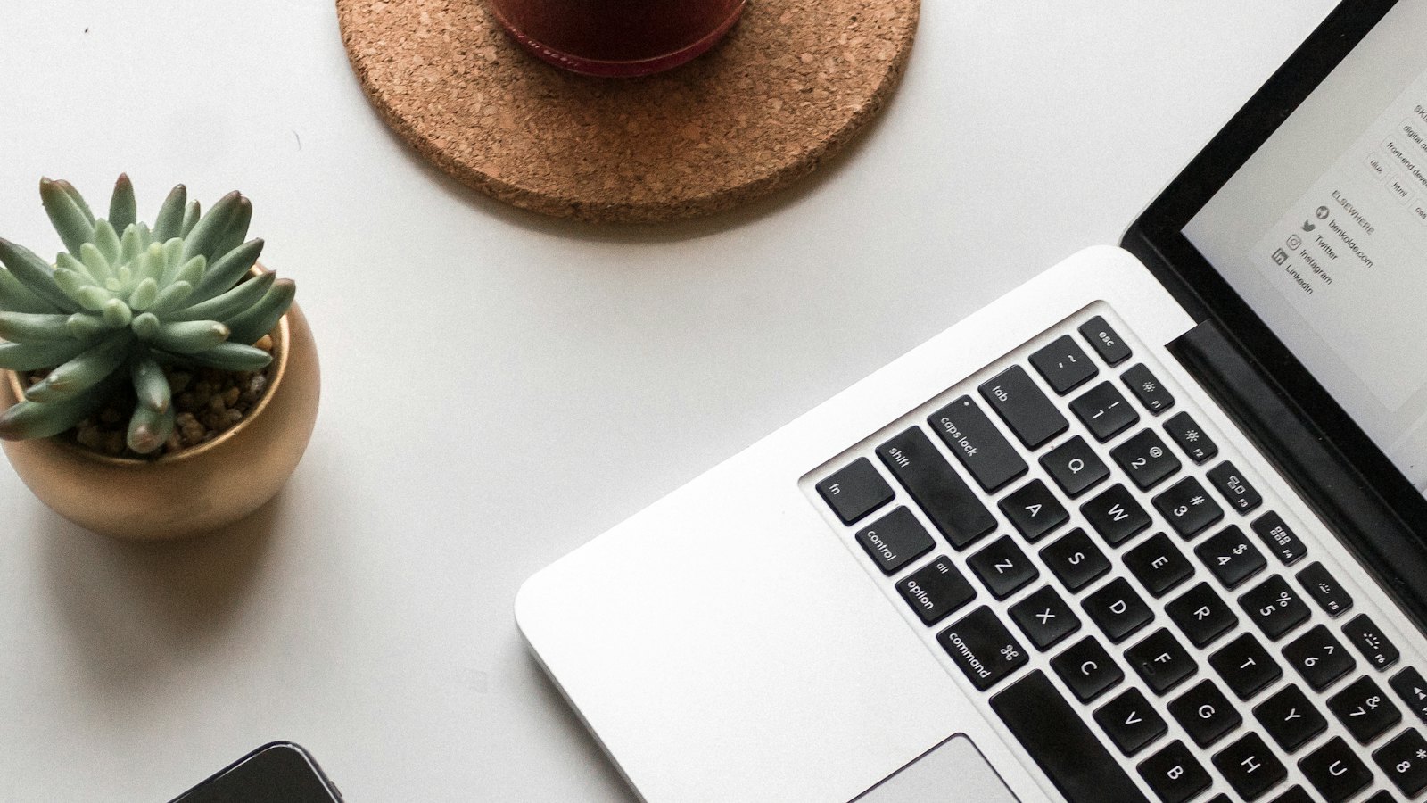 A laptop and a smartphone on a white desk