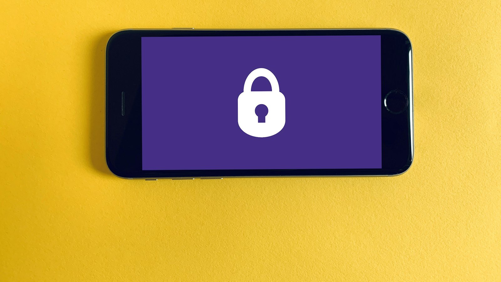 A smartphone showing a padlock icon on a yellow background